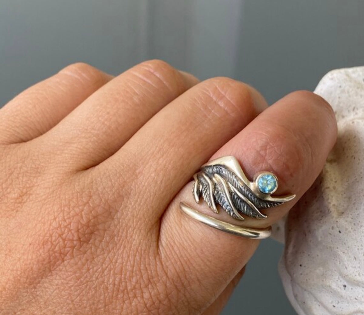 silver angel wing with a blue topaz