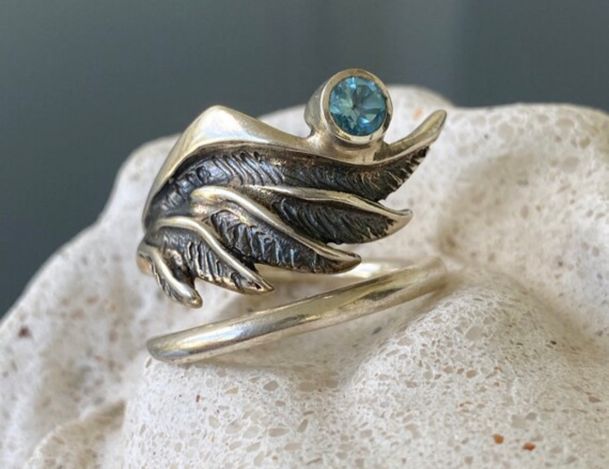 silver angel wing with a blue topaz
